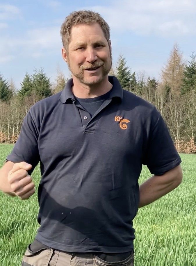 A man standing in a field of crops.